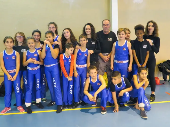 Une vingtaine de jeunes du TCMS en tenue de savate bleue, avec leurs entraîneurs, lors d’un interclub.