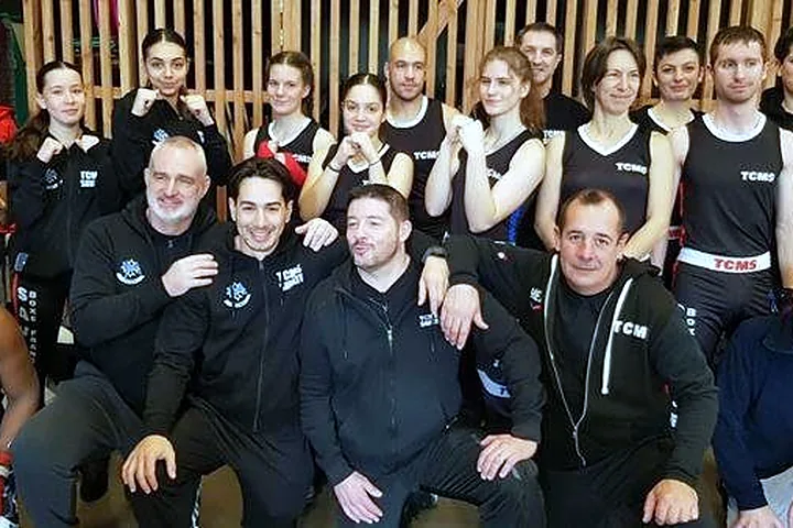 Les adultes du TCMS réunis lors d’un interclub à Saint-Orens, poings levés, entraîneurs accroupis au premier rang.